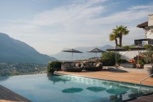 a swimming pool with two chairs and umbrellas at Golserhof in Tirolo