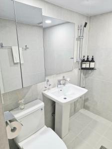 a white bathroom with a toilet and a sink at Stay Dasony in Gyeongju
