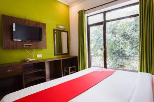 a bedroom with a bed and a window and a television at Hotel pramod palace in Khajurāho