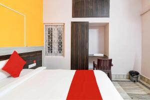 a bedroom with a bed with a red pillow and a desk at Hotel pramod palace in Khajurāho