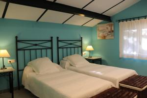 two beds in a room with blue walls at LIDENEX in Guijo de Granadilla +43 photos