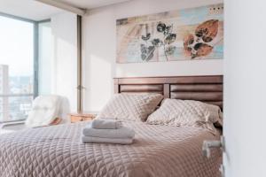 ein Schlafzimmer mit einem Bett mit einem Stapel Handtücher drauf in der Unterkunft Magnificent ocean view from downtown Viña in Viña del Mar + 30 Fotos