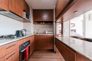 eine Küche mit Holzschränken und einer Arbeitsplatte in der Unterkunft Magnificent ocean view from downtown Viña in Viña del Mar