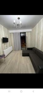 トビリシにあるKomfort Houseのソファとテレビのあるリビングルーム