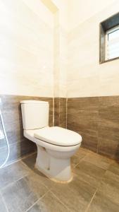 aseo blanco en un baño con ventana en Nakshatra residency, en Coimbatore