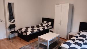 a living room with two beds and a table at Crew Quartier ALL-INCLUSIVE Serviced Apartment in Krostitz in Krostitz +3 photos