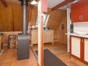 - une cuisine avec un poêle à bois dans une maison dans l'établissement 4 person holiday home in Rømø, à Lakolk 39 autres photos