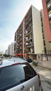 een auto geparkeerd voor een groot gebouw bij Komfort House in Tbilisi City