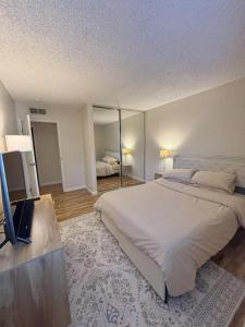 ein Schlafzimmer mit einem großen weißen Bett und einem Fernseher in der Unterkunft Near Lake, Golf and Tennis - Reno Condo in Reno