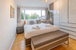 a bedroom with a large bed and a window at Pass the Keys 3-Bedroom Home in Chelmsford Sleeps 7 in Great Baddow