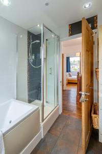 a bathroom with a shower and a bath tub at Pass the Keys 3-Bedroom Home in Chelmsford Sleeps 7 in Great Baddow +40 photos