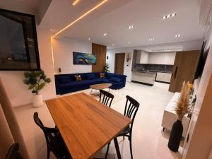 a living room with a table and a blue couch at Appartement Luxe S2-900m-plage-Fibre-Smart TV-Parking privé in Nabeul