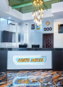 Un vestíbulo de hotel con el letrero del hotel Aania en el mostrador en Asato Hotel, en Asaba