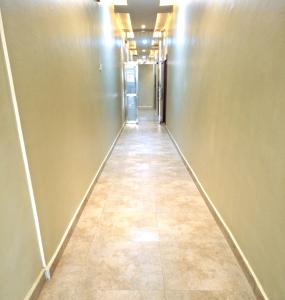 un pasillo largo con suelo de baldosa en un edificio en Asato Hotel, en Asaba