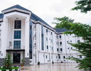 un edificio blanco con techo negro en Asato Hotel, en Asaba