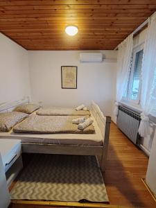 a bedroom with a bed with a wooden ceiling at Sobe Đakovački vezovi in Đakovo