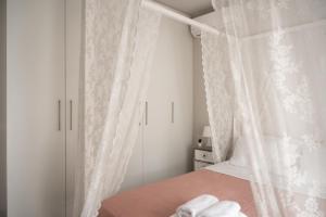 Villa Evanthia في Áyios Yeóryios: غرفة نوم بيضاء مع سرير مع مظلة +41 صورة