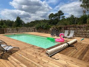 a swimming pool with a pink flamingo in the water at Domaine Le Chalet de Brousses in Brousses-et-Villaret
