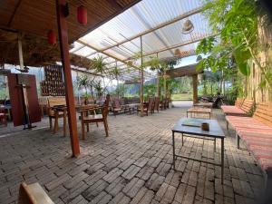 a patio with tables and chairs and a glass roof at Big J gest house in Ninh Binh