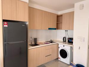 een keuken met een zwarte koelkast en een vaatwasser bij Subang Studio 6 Pax Home in Subang Jaya