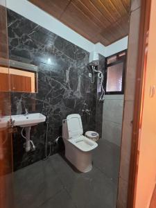 a bathroom with a toilet and a sink at Hotel Prithesh Tourist Home in Bantvāl