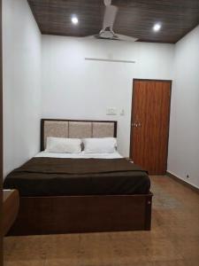 a bedroom with a bed and a wooden door at Hotel Prithesh Tourist Home in Bantvāl
