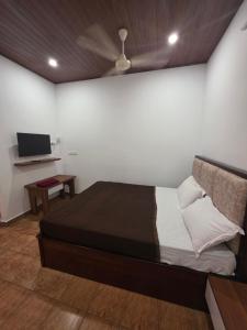 a bedroom with a bed with a ceiling fan at Hotel Prithesh Tourist Home in Bantvāl