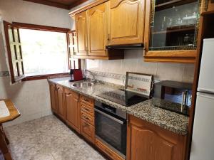 a kitchen with wooden cabinets and a counter top at Rincón de Madagascar VV-2192-AS in Arriondas
