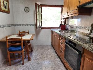 a kitchen with a wooden table and a small table with a sink at Rincón de Madagascar VV-2192-AS in Arriondas