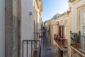 Un callejón en un casco antiguo con edificios. en La Dimora di San Nicola Ortigia Boutique Apartments - Terrace & Jacuzzi Access, en Siracusa