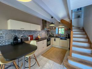a kitchen with a table and a staircase in a house at Ty Levenez in Paimpol