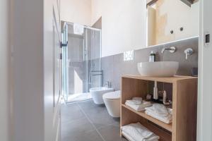 un baño con lavabo e inodoro en La Dimora di San Nicola Ortigia Boutique Apartments - Terrace & Jacuzzi Access, en Siracusa 42 fotos más