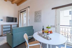 una sala de estar con una mesa y un sofá en La Dimora di San Nicola Ortigia Boutique Apartments - Terrace & Jacuzzi Access, en Siracusa