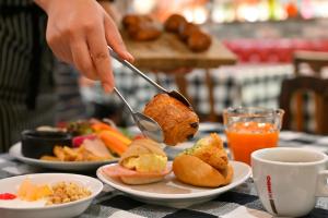 a person is eating a piece of food with a spoon at Hotel Resol Kyoto Shijo Muromachi in Kyoto