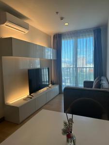 a living room with a flat screen tv and a couch at astra sharingla view top floor in Chiang Mai