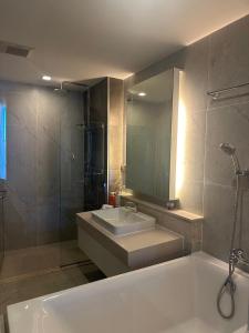 a bathroom with a tub and a sink and a mirror at astra sharingla view top floor in Chiang Mai