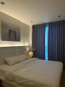 a bedroom with a large bed and a window at astra sharingla view top floor in Chiang Mai +5 photos