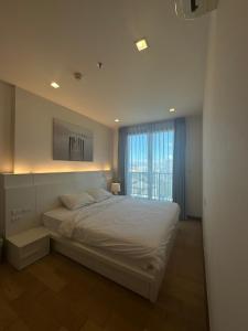 a bedroom with a large bed and a window at astra sharingla view top floor in Chiang Mai