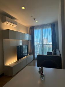 a living room with a tv and a couch and a table at astra sharingla view top floor in Chiang Mai