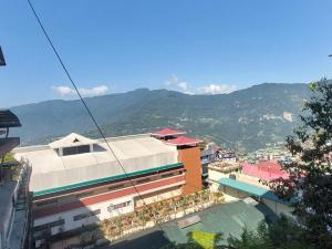 a group of buildings with mountains in the background at Hotel Rashak - Mg Marg in Gangtok