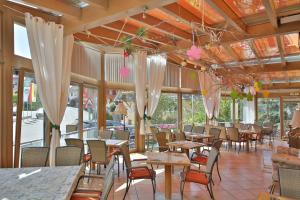 a restaurant with tables and chairs and windows at Hotel Restaurant Freihof in Oberharmersbach
