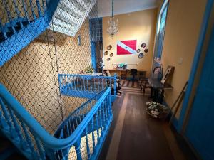 a room with a staircase with blue railing and a living room at General Hostel Belém in Belém
