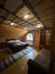 a bedroom with a bed in a log cabin at Лісова тиша Сімейні номера in Synevyrsʼka Polyana