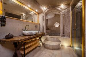 um banheiro com pia e banheira em Eyes Of Cappadocia Cave Hotel em Üçhisar mais 144 fotografias