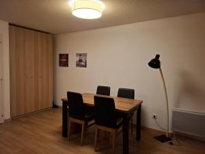 een eettafel met stoelen en een lamp bij Très bel appartement dans le centre d'Isola 2000 avec balcon exposé sud ouest in Isola 2000 +3 foto's