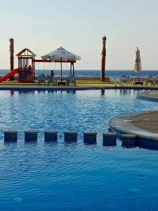 Long Island Resort - K25- Family only في مرسى مطروح: مسبح مع ملعب و زحليقة مائية