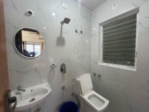 a bathroom with a sink and a toilet and a mirror at Hotel O SRS COMFORTS in Tāvarikere