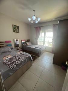 Long Island Resort - K25- Family only في مرسى مطروح: غرفة نوم بها سريرين وثريا