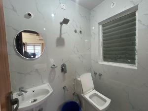 a bathroom with a sink and a toilet and a mirror at Hotel O SRS COMFORTS in Tāvarikere