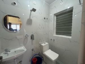 a bathroom with a toilet and a sink and a mirror at Hotel O SRS COMFORTS in Tāvarikere
